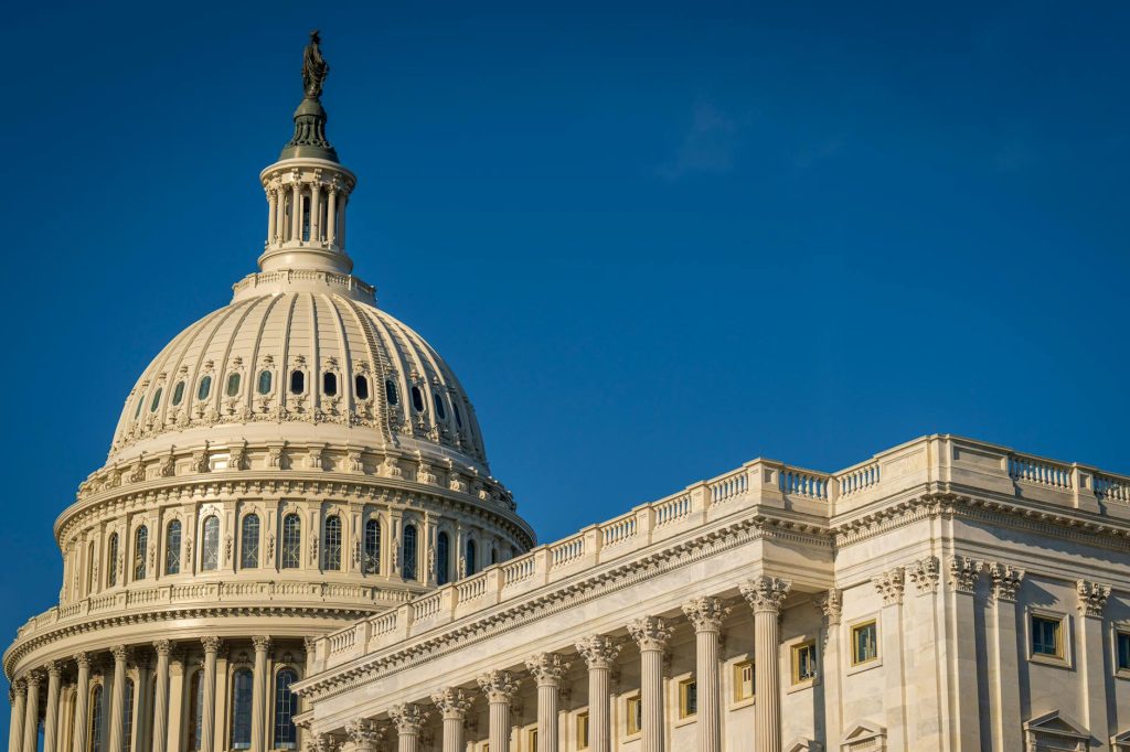 The U.S. Capitol dome under a clear blue sky, photographed from the west lawn.